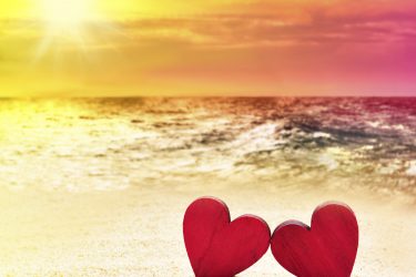 Two of wooden red heart on the beach